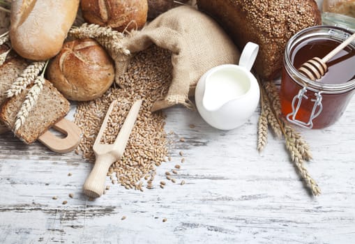 Freshly baked bread rolls, wheat ears and honey