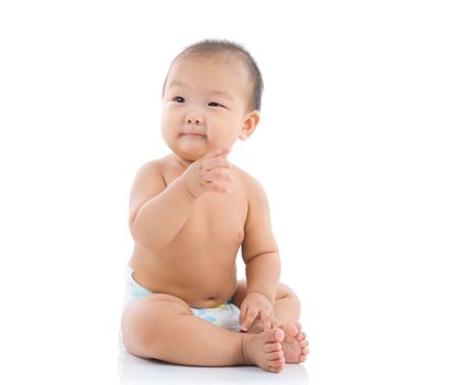 cute asian baby sitting on the floor isolated on white background