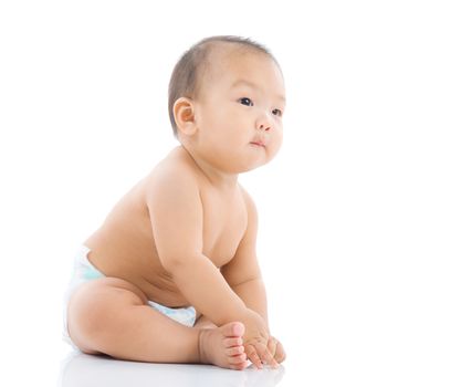 cute asian baby sitting on the floor isolated on white background