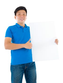 Asian businessman holding a blank card board with copy space, standing on plain background.