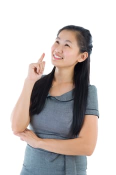 Businesswoman having a thought, looking up smiling happy. Portrait of beautiful Asian female model standing isolated on white background.