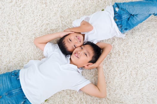 Lovely asian kids lying on the floor