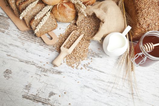 Freshly baked bread rolls, wheat ears and honey