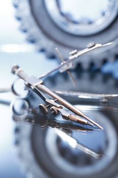 Industrial concept. Divider and gear on glass surface against gray background