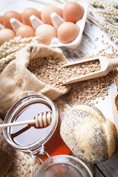 Freshly baked bread rolls, wheat ears and honey