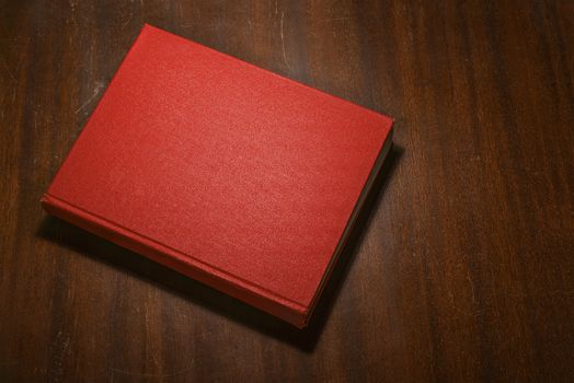 Red book on the wooden scratched table