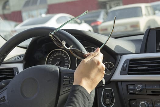 the girl behind the wheel of the car keeps sunglasses