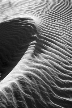 Black and white background of nature on sand hill, amazing wavy pattern with abstract shape and shadow, amzing art from sand in monotone