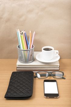 office desk : coffee with phone,stack of book,eyeglasses,wallet,color pencil box on wood background