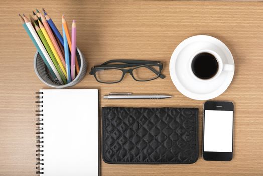 office desk : coffee with phone,notepad,eyeglasses,wallet,color pencil box on wood background