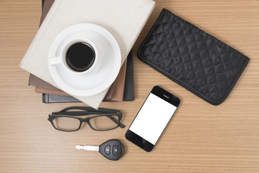 coffee and phone with stack of book,car key,eyeglasses and wallet on wood background