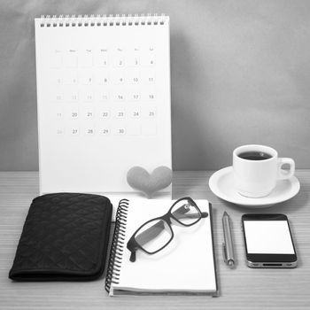 office desk : coffee with phone,wallet,calendar,heart,notepad,eyeglasses,heart on wood background black and white color