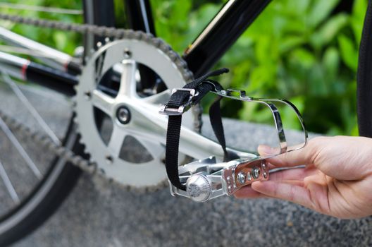 Close up of hand with bicycle pedal 