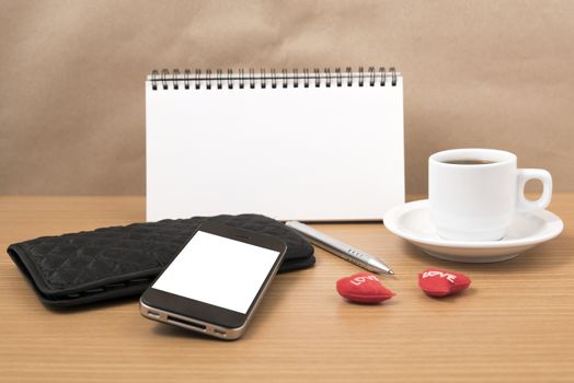 working table : coffee with phone,notepad,wallet and red heart on wood background