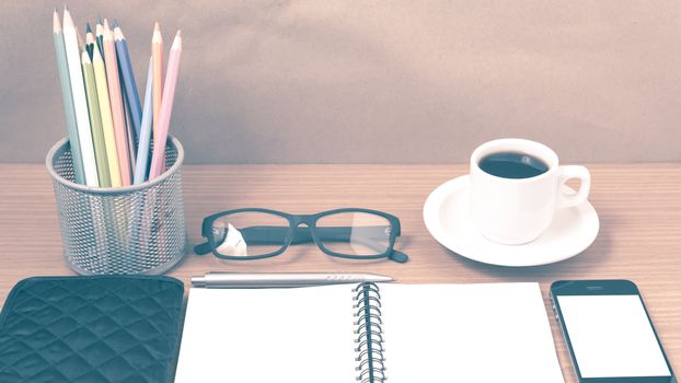 office desk : coffee with phone,notepad,eyeglasses,wallet,color pencil box on wood background vintage style