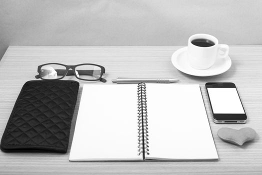 office desk : coffee with phone,notepad,eyeglasses,wallet,heart on wood background black and white color