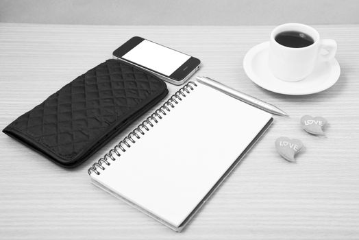 working table : coffee with phone,notepad,wallet and red heart on wood background black and white color