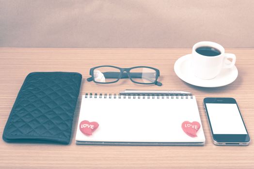 office desk : coffee with phone,notepad,eyeglasses,wallet,heart on wood background vintage style