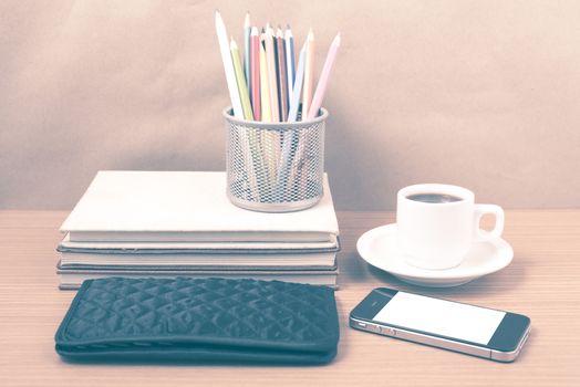 office desk : coffee with phone,stack of book,wallet,color box on wood background vintage style