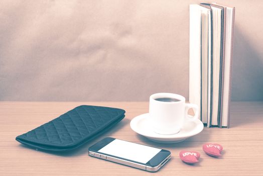 office desk : coffee with phone,heart,stack of book,wallet on wood background vintage style