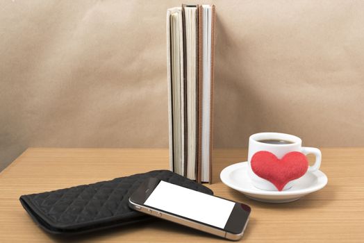 working table : coffee with phone,stack of book,wallet and heart on wood background