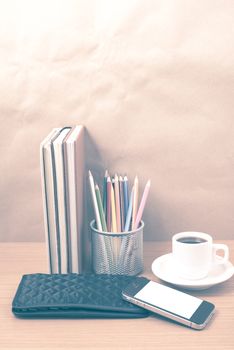 office desk : coffee with phone,stack of book,wallet,color box on wood background vintage style