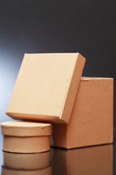 Two cardboard boxes with reflection on dark background