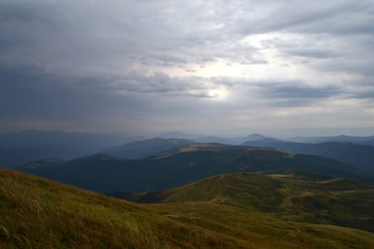 Mountain peaks in the autumn evening sky with clouds