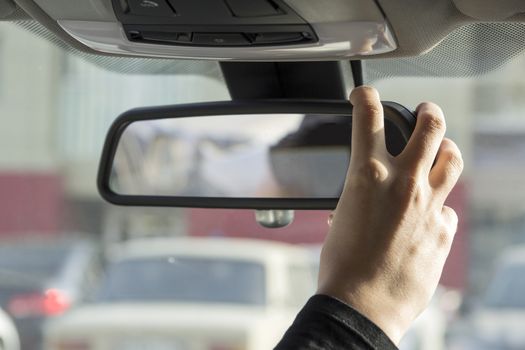 girl adjusts the rearview mirror
