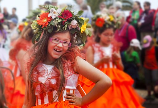 Performers with colorful and elaborate costumes taking part in the Parade of Flower Festival on the Madeira Island, Portugal.