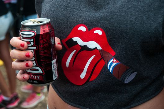 CUBA, Havana: A picture is taken of a black t-shirt with the Rolling Stones mouth logo smoking a Cuban cigar on it as Rolling Stones fans wait for the start of a free concert on March 25, 2016 in Havana, Cuba. Thousands of fans waited for the Rolling Stones to play for the first time in Cuba, after the music was once banned by the government.
