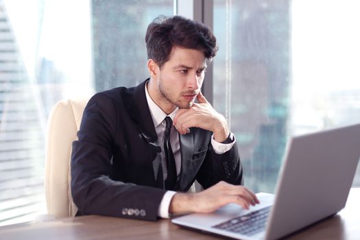 Busy businessman in office working on his laptop.