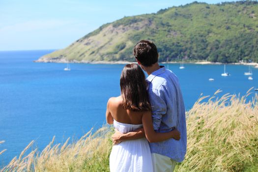 Young couple on vacation looking at sea together