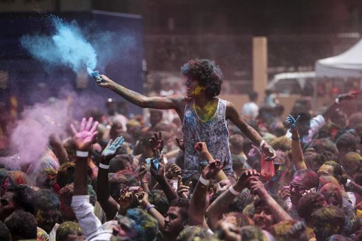 MALAYSIA, Kuala Lumpur: A man throws colored powder away as revellers dance and spray colored powder during the Holi Festival in Kuala Lumpur on March 26, 2016. Holi, also called the Festival of Colours, is a popular Hindu spring festival observed in India, Malaysia and other countries at the end of the winter season on the last full moon day of the lunar month. 