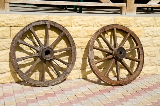 Wooden wheels of old carts hung on a wall.