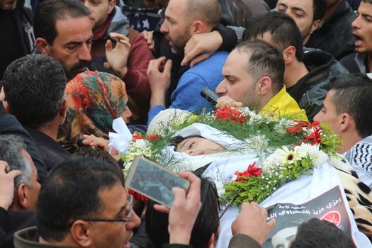 WEST BANK, Hebron: Relatives and Hebron residents mourn the body of Ramzi al-Qasrawi, 21, a Palestinian man shot dead by an Israeli soldier in a reported stabbing attack, during his funeral in the West Bank town of Hebron on March 26, 2016. Ramzi al-Qasrawi was killed on March 24, 2016 along with Abdul Fatah al-Sharif after they, the Israeli army said, wounded an Israeli soldier at the entrance to the heavily guarded Jewish settler enclave in the heart of the city.
