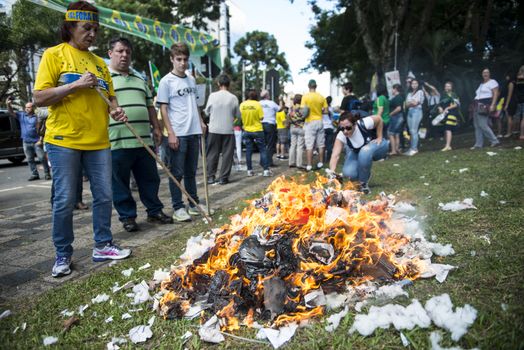 BRAZIL, Curitiba: Protesters burn the remains of effigies in front of the Federal Court in Curitiba, Brazil on March 26, 2016.Traditionally on the Saturday before Easter, Catholics beat effigies of Judas the apostle. This year protesters in favor of impeachment of the President of Brazil, used the tradition as a political demonstration.