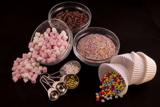 Different cake decorations laid out against a black background