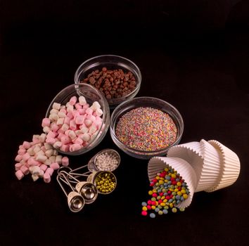 Different cake decorations laid out against a black background