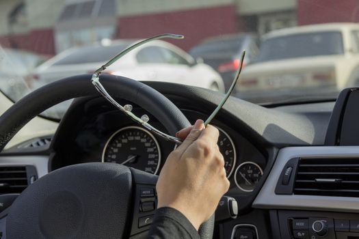 the girl behind the wheel of the car keeps sunglasses