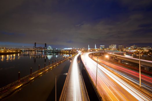 Freeway traffic light trails along Willamette River with city of Portland Oregon skyline at night