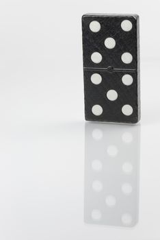 Standing black domino brick with white dots
