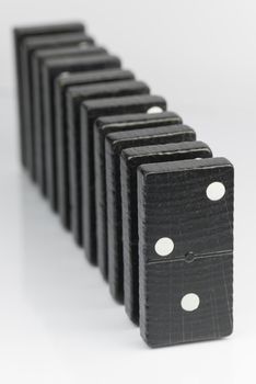 Composition of standing black domino bricks with white dots
