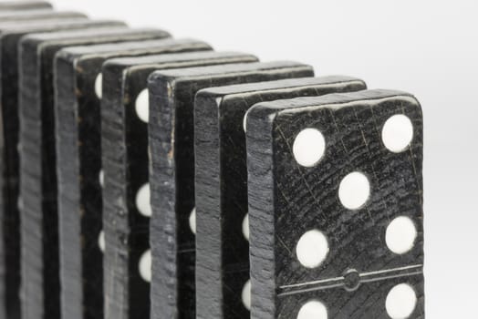 Composition of standing black domino bricks with white dots
