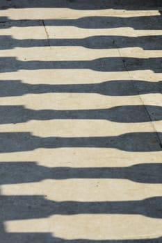 Shadows of pillar on concrete path