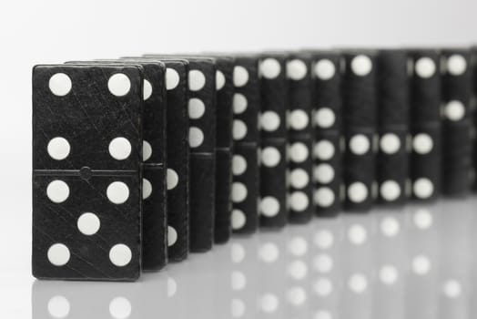 Composition of standing black domino bricks with white dots
