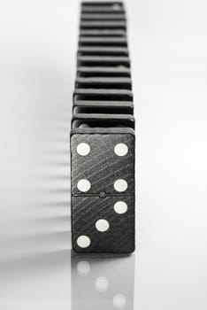 Composition of standing black domino bricks with white dots
