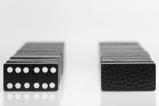 Composition of standing black domino bricks with white dots
