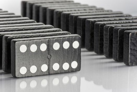 Composition of standing black domino bricks with white dots
