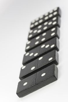 Composition of lying black domino bricks with white dots
